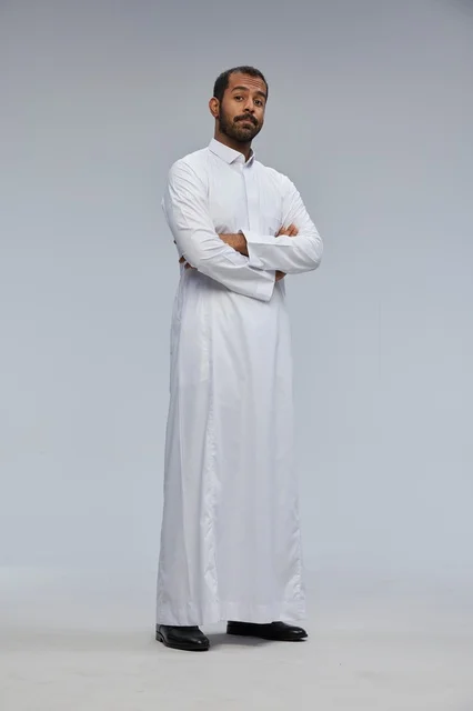 رجل سعودي بالثوب الأبيض مكتوف الذراعين بورتريه كامل