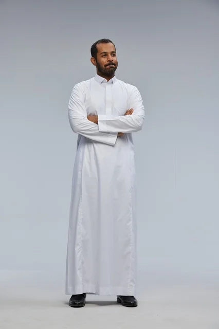 رجل سعودي بالثوب الأبيض مكتوف الذراعين في الاستوديو