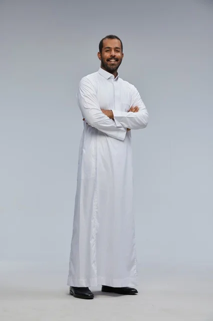 رجل سعودي بالثوب الأبيض مكتوف الذراعين في الاستوديو