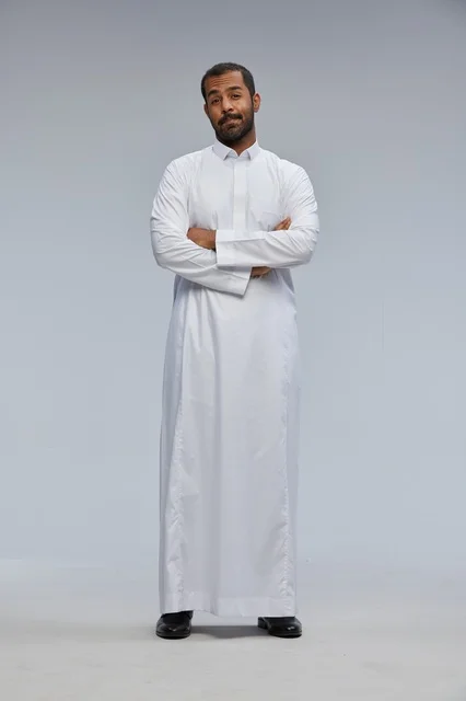 رجل سعودي بالثوب الأبيض مكتوف الذراعين بورتريه استوديو