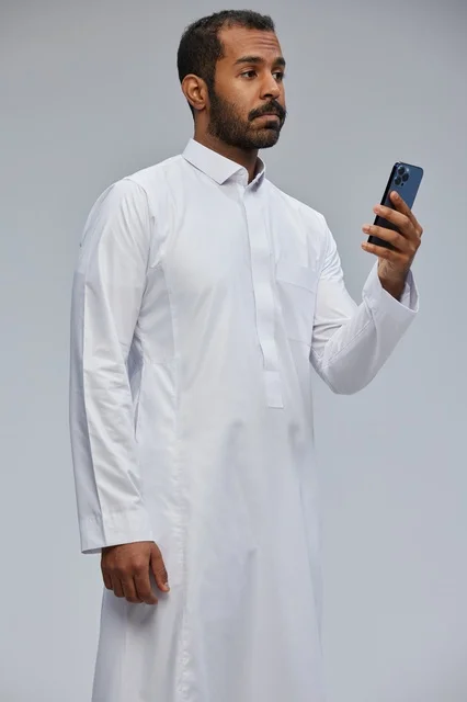 Saudi Man in White Thobe Using Smartphone in Studio