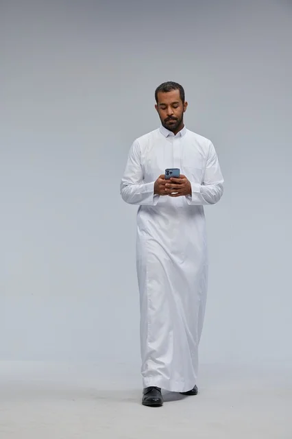Saudi Man in White Thobe Using Smartphone Studio