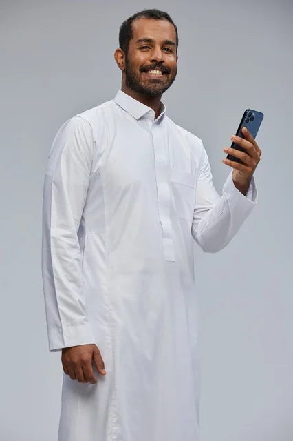 Saudi Man in White Thobe Holding Smartphone Studio