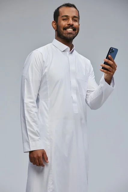 Saudi Man in Thobe Using Smartphone Studio Portrait
