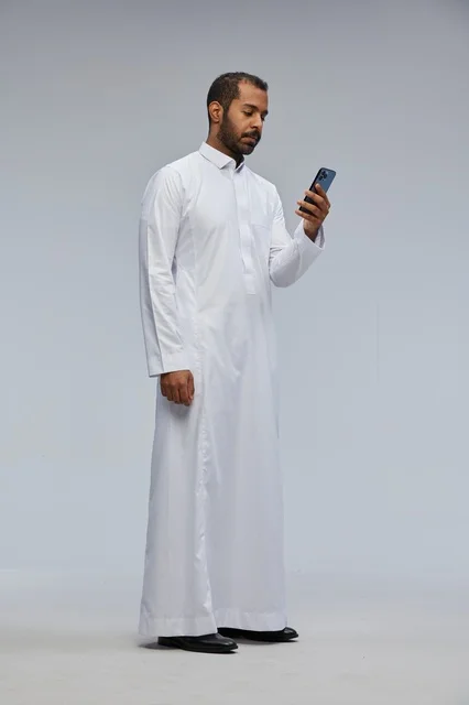 Saudi Man in White Thobe Using Smartphone in Studio