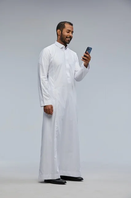 Saudi Man in White Thobe Using Smartphone in Studio