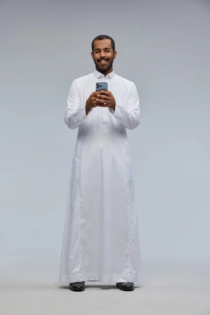 Saudi Man in White Thobe Using Smartphone in Studio