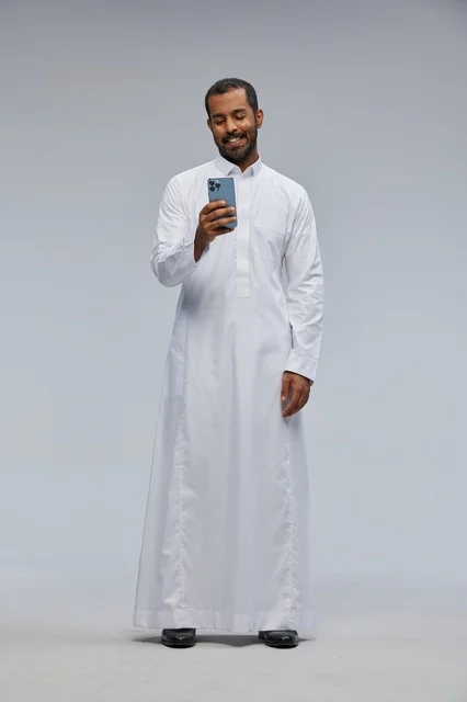 Saudi Man in White Thobe Using Smartphone Studio Shot