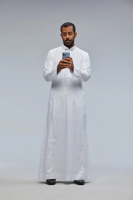 Saudi Man in White Thobe Using Smartphone in Studio
