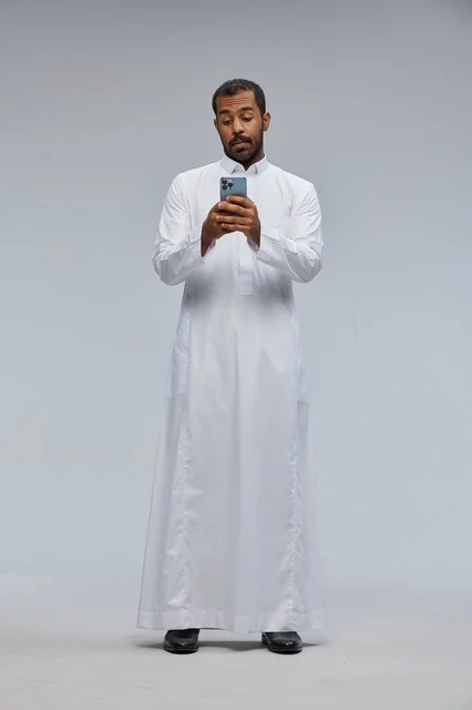 Saudi Man in White Thobe Using Smartphone Studio Shot