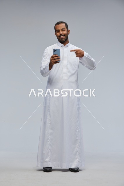 Saudi Man in White Thobe Pointing at Smartphone Studio