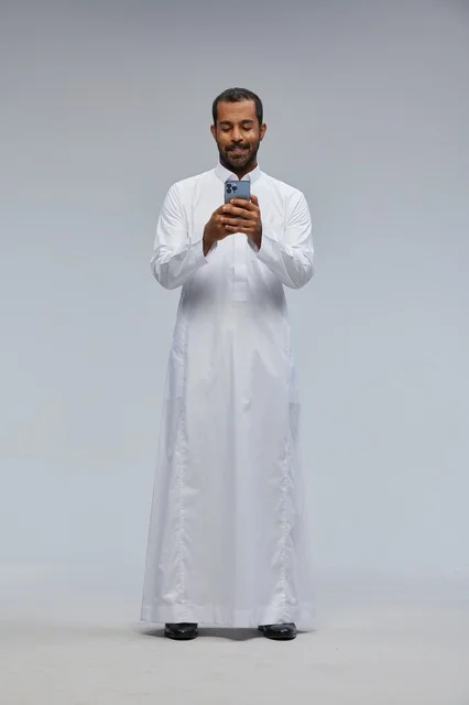 Saudi Man in White Thobe Using Smartphone in Studio