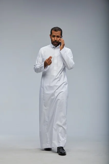 Saudi Man in White Thobe Talking on Smartphone Studio