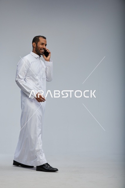 رجل سعودي بالثوب يتحدث بالهاتف في الاستوديو