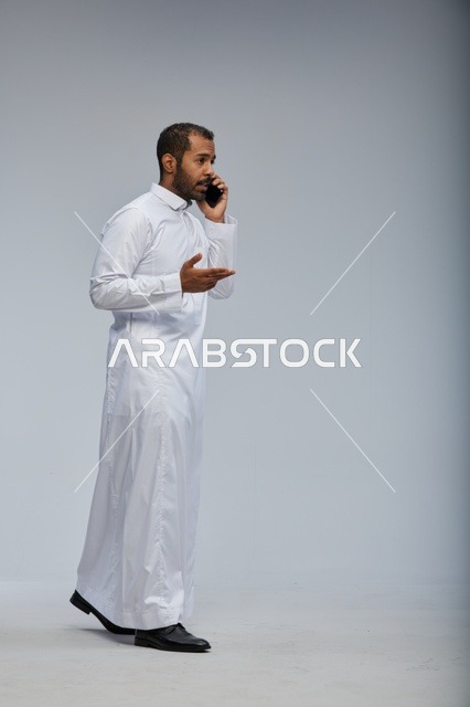 رجل سعودي بالثوب الأبيض يتحدث بالجوال