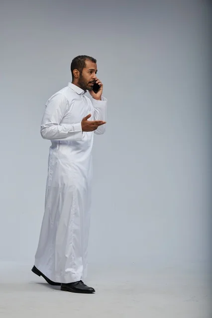 رجل سعودي بالثوب الأبيض يتحدث بالجوال
