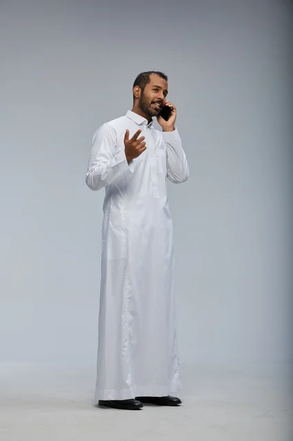 رجل سعودي بالثوب الأبيض يتحدث في الجوال تصوير استوديو