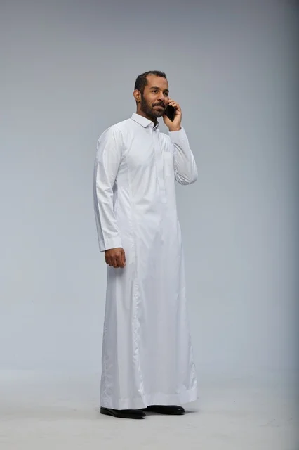 Saudi Man in White Thobe Talking on Smartphone Studio