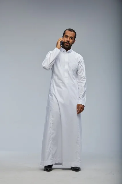 Saudi Man in White Thobe Talking on Smartphone Studio