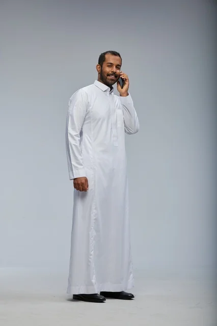 Saudi Man in White Thobe Talking on Smartphone Studio