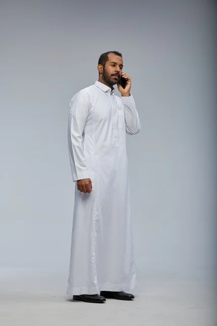 رجل سعودي بالثوب الأبيض يتحدث بالجوال