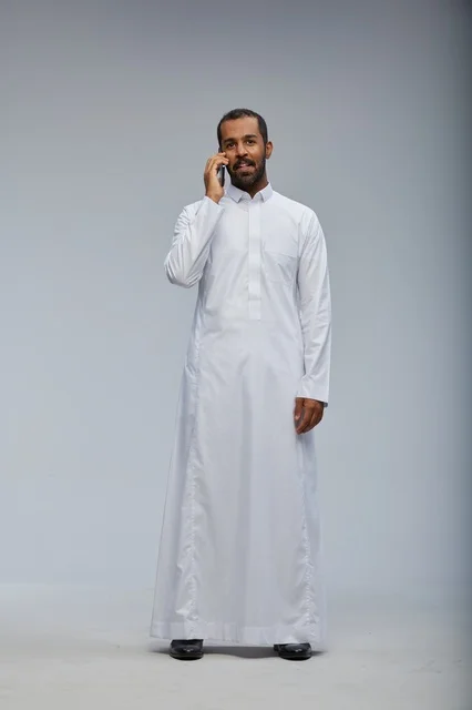 Saudi Man in White Thobe Talking on Smartphone Studio