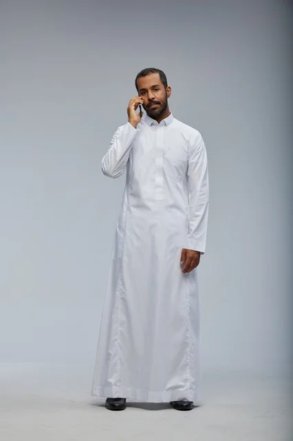Saudi Man in White Thobe Talking on Smartphone Studio