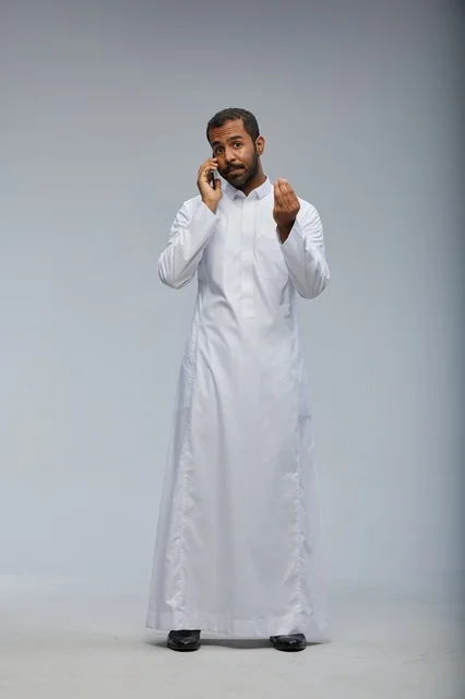 رجل سعودي يرتدي الثوب الأبيض يتحدث بالجوال في استوديو