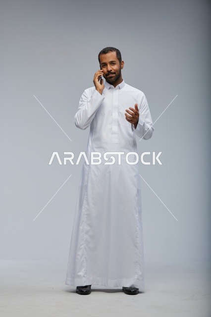 رجل سعودي بالثوب الأبيض يتحدث عبر الجوال