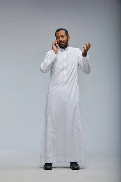 رجل سعودي بالثوب الأبيض يتحدث بالجوال