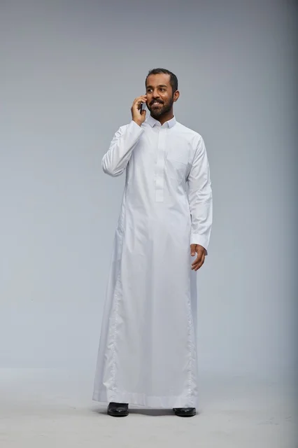 Saudi Man in White Thobe Talking on Smartphone Studio