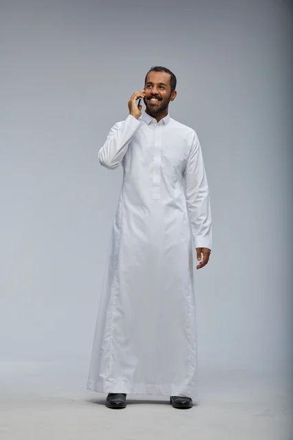 Saudi Man in White Thobe Talking on Smartphone Studio