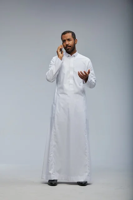 Saudi Man in White Thobe Talking on Smartphone Studio