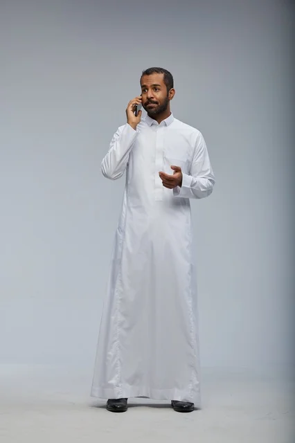 Saudi Man in White Thobe Talking on Smartphone Studio