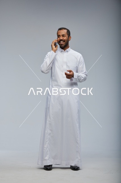 رجل سعودي بالثوب الأبيض يتحدث في الجوال تصوير استوديو