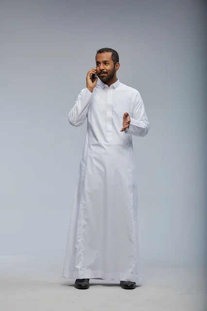 Saudi Man in White Thobe Talking on Smartphone Studio