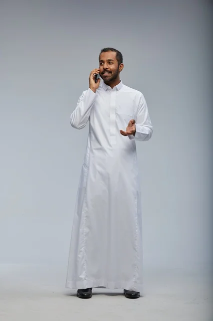 Saudi Man in White Thobe Talking on Smartphone Studio