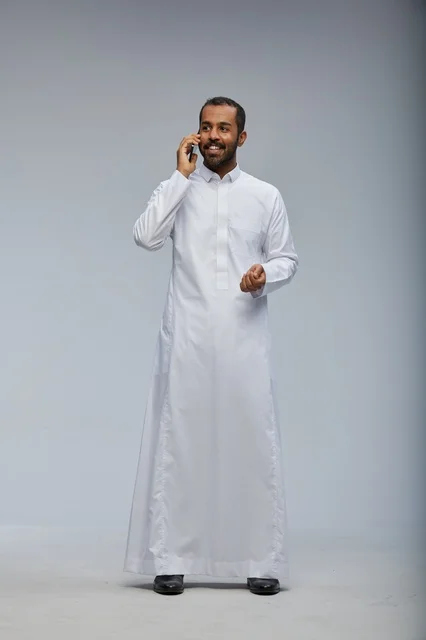 Saudi Man in White Thobe Talking on Smartphone Studio