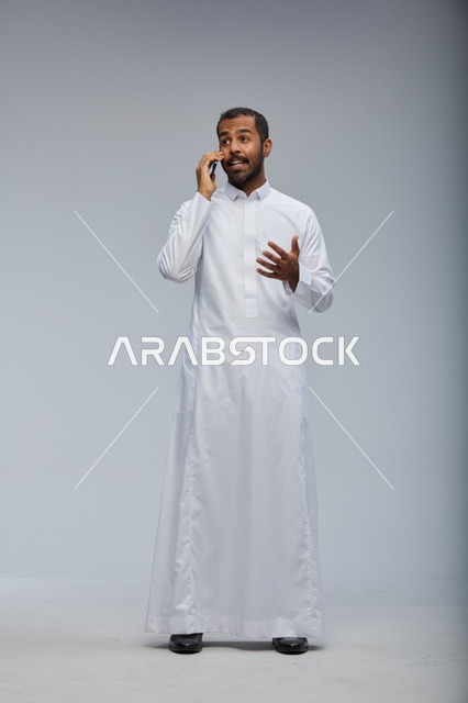 Saudi Man in White Thobe Talking on Smartphone in Studio