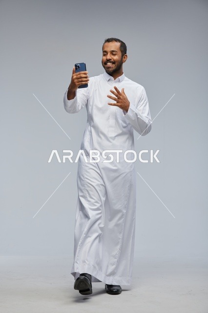 Saudi Man in White Thobe with Smartphone Selfie