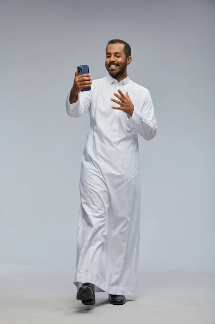 Saudi Man in White Thobe with Smartphone Selfie