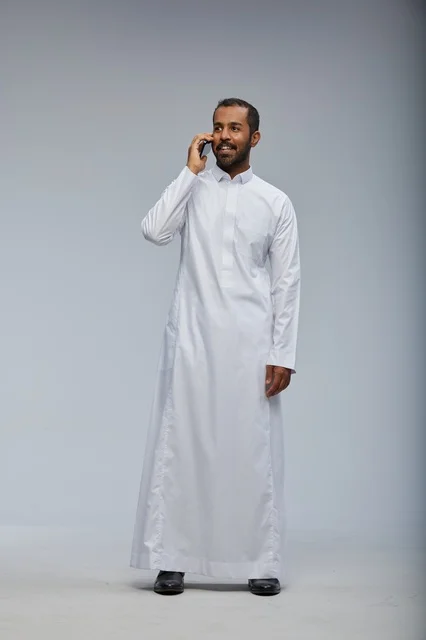 Saudi Man in White Thobe Talking on Smartphone Studio
