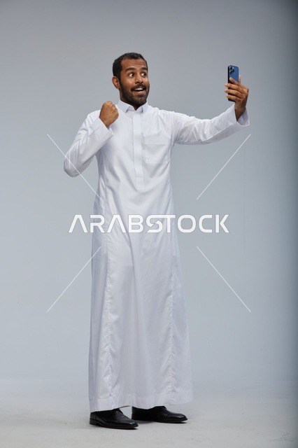 Saudi Man in Thobe Taking Selfie with Smartphone