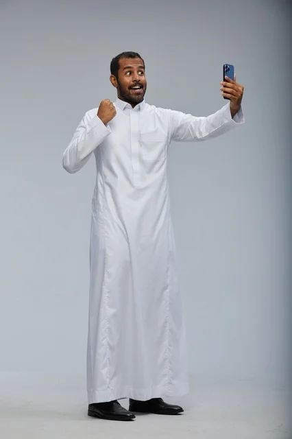 Saudi Man in Thobe Taking Selfie with Smartphone
