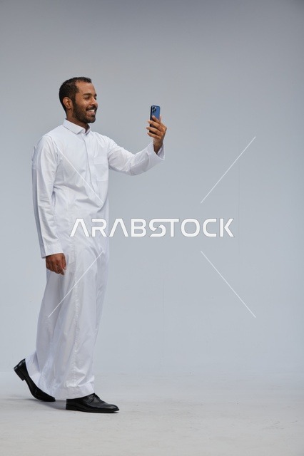 Saudi Man in White Thobe Taking Selfie in Studio