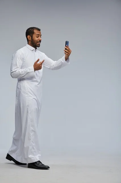 Saudi Man in White Thobe Taking Smartphone Selfie