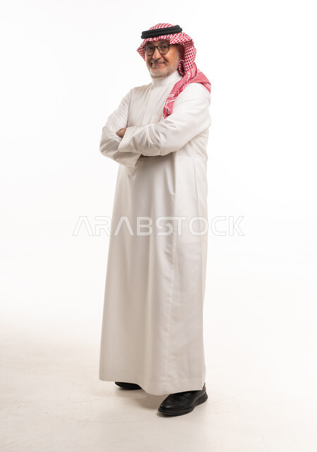 رجل سعودي بملابس تقليدية يقف أمام خلفية بيضاء
