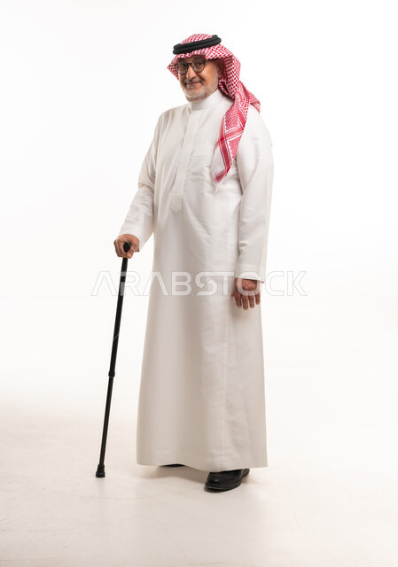 رجل سعودي مسن بالزي التقليدي يحمل عصا مشي