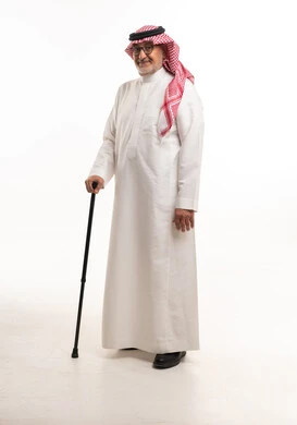 رجل سعودي مسن بالزي التقليدي يحمل عصا مشي