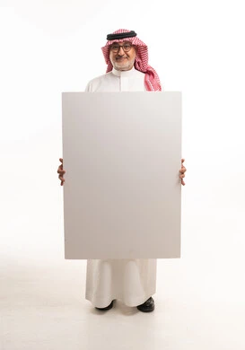 رجل سعودي يمسك بلوحة بيضاء فارغة في استوديو رجل سعودي يمسك بلوحة بيضاء فارغة في استوديو